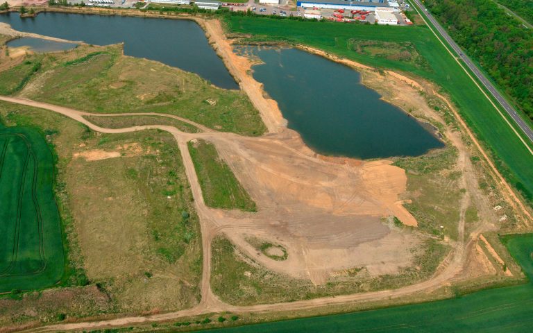 Luftaufnahme des Kieswerks Merseburg mit mehreren Wasserflächen, befestigten Fahrwegen und großflächigen Abbauarealen.